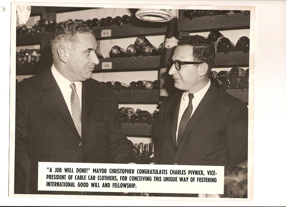 Archival press photograph: Mayor Christopher congratulating Charles Pivnick, vice president of Cable Car Clothiers